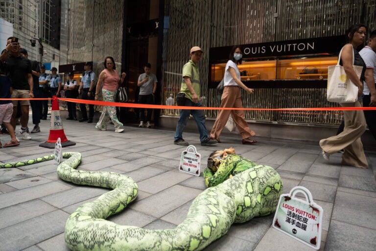 Activista protesta disfrazada de pitón frente a Louis Vuitton en Hong Kong