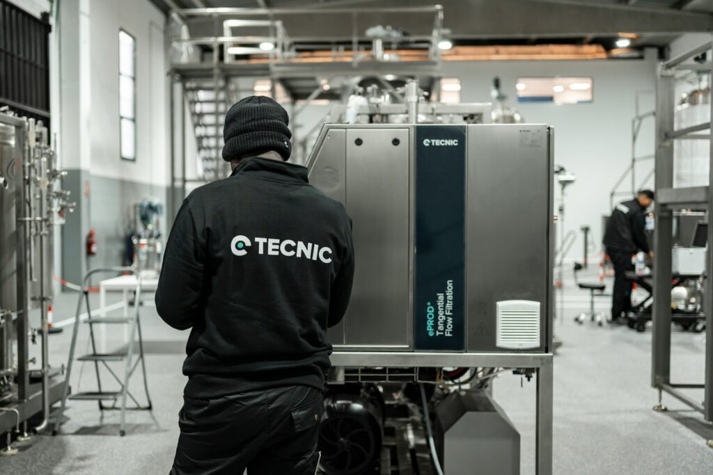 Worker looking at industrial machinery in a factory.