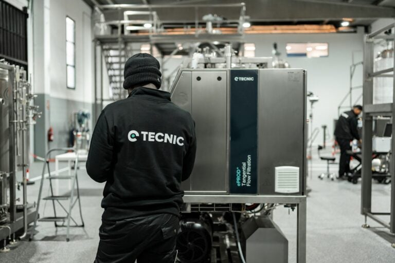 Worker looking at industrial machinery in a factory.