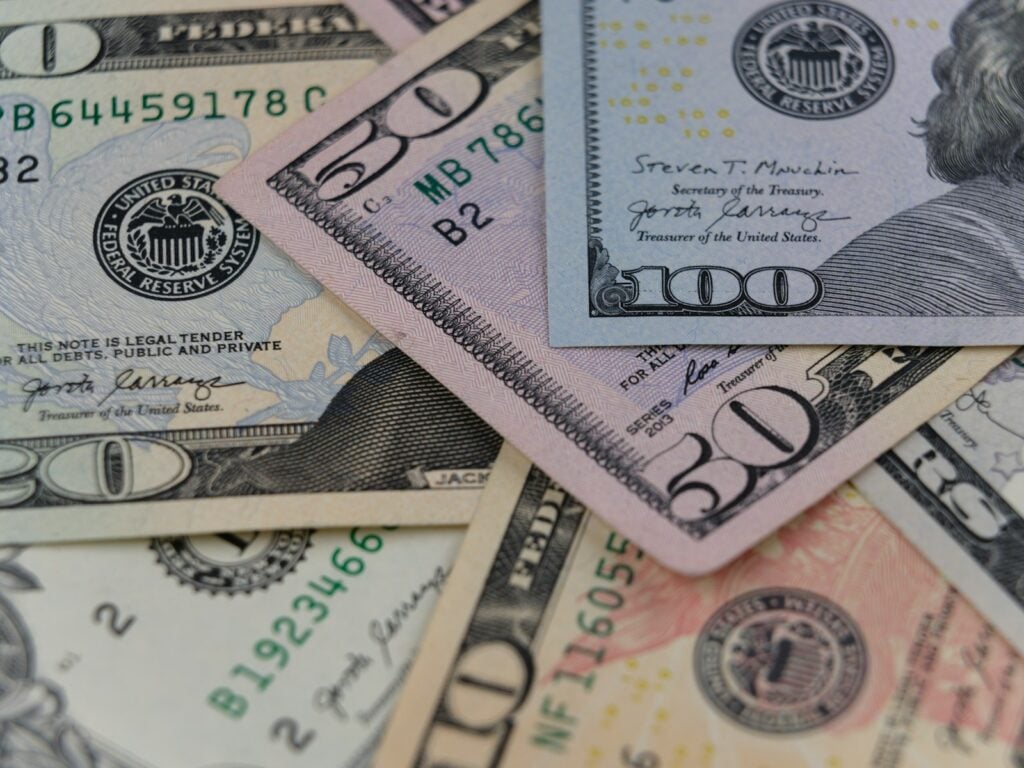 a pile of twenty dollar bills laying on top of each other
