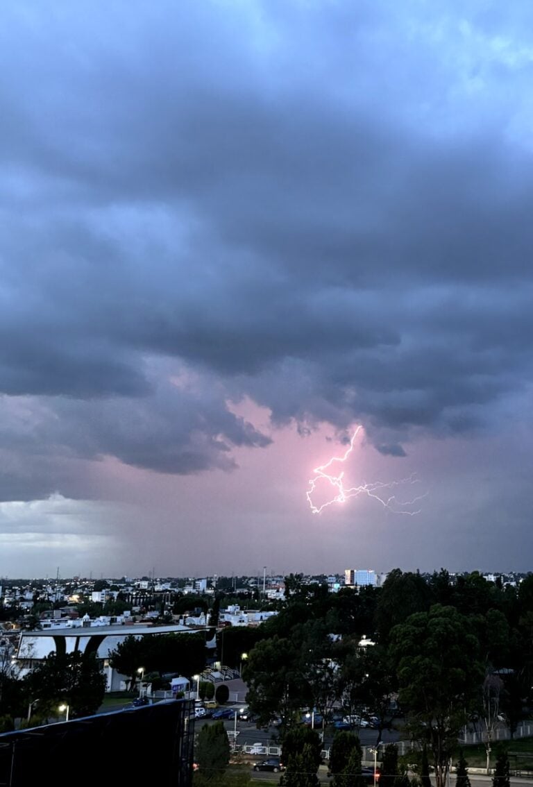 A lightning bolt is seen in the sky over a city