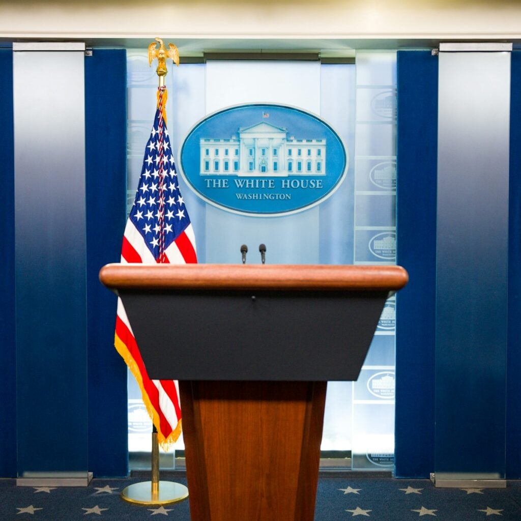 a podium with an american flag and the white house