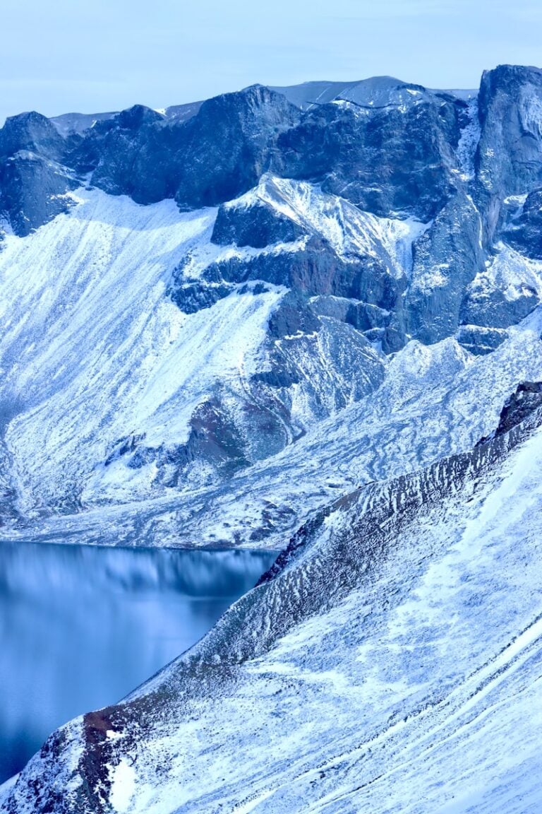A snow covered mountain with a lake in the middle
