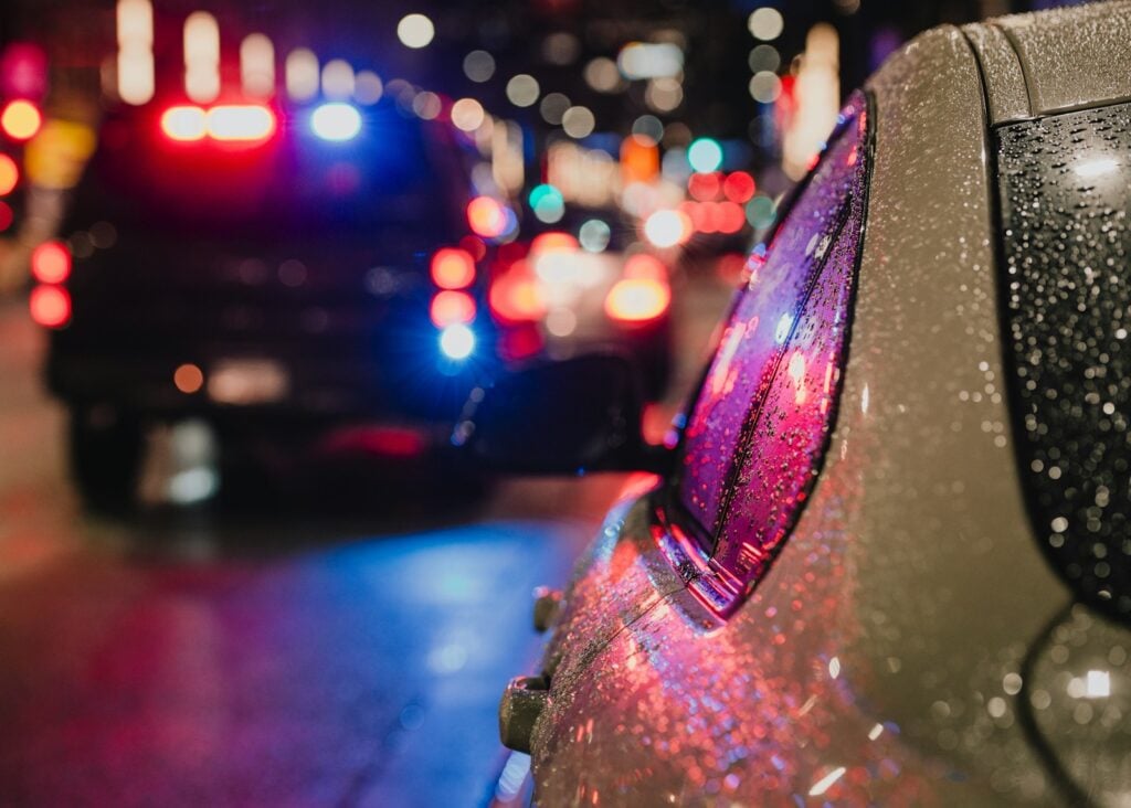 Police car with flashing lights on city street.