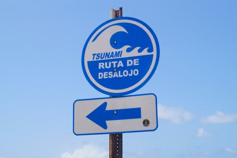 Tsunami evacuation route sign pointing left.