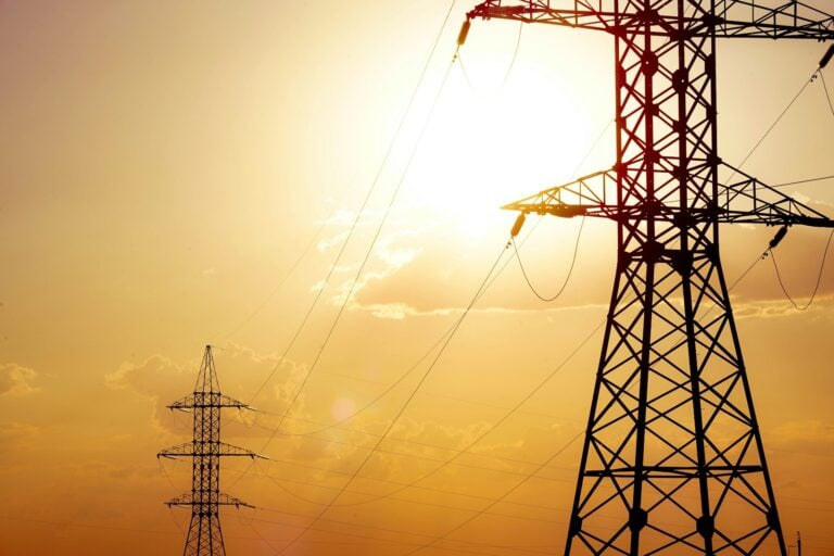 Power lines against a bright, yellow sky.