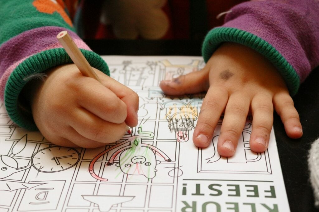 a child is drawing on a piece of paper