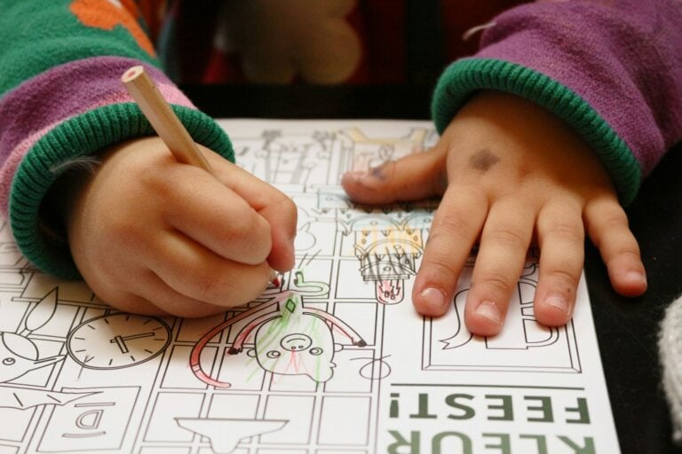 a child is drawing on a piece of paper