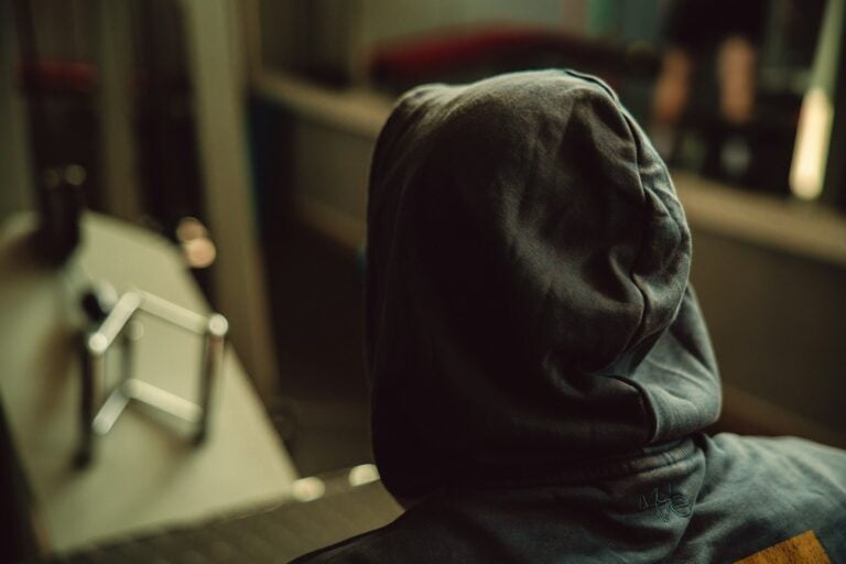 A person in a hoodie looks away.